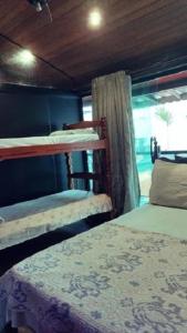 1 dormitorio con 2 literas y ventana en Suites Malibu, en Arraial do Cabo