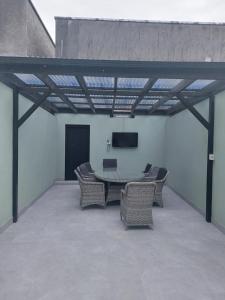a patio with a table and chairs and a screen at Tribeca Stay in Galway