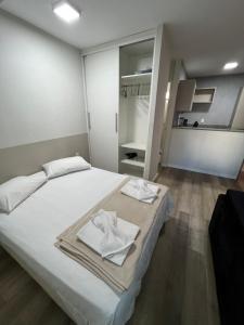 a bedroom with a white bed with towels on it at Flat Boa Viagem luxo in Recife
