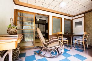a room with a desk and chairs and a table at Guest House Kura in Suzaka