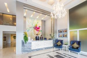 a lobby of a hotel with a woman standing at a counter at Pratunam City Inn in Bangkok