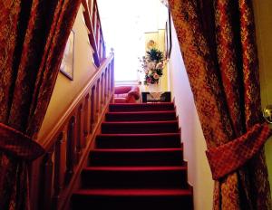 a stairway with red carpeting and red curtains at Hotel Moderno Restaurant in Serina