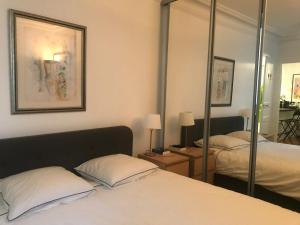 a bedroom with two beds and a mirror at Cosy Flat 1 BDR Arc de Triomphe Champs Elysées in Paris