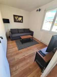 ein Wohnzimmer mit einem Sofa und einem Tisch in der Unterkunft T2 rénové avec parking gratuit sur place in Valence