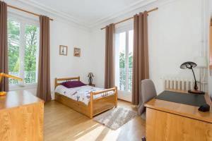 sypialnia z łóżkiem i biurkiem w obiekcie J'aime Paris 1st w mieście Boulogne-Billancourt