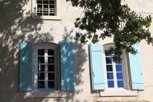 two windows with blue shutters on a building at Le Mas Turquoise, B&B Spa-Color Inclus in Bédarrides