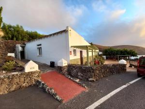 a building with a stone wall and a red carpet at Centro Ave Fénix in Femés