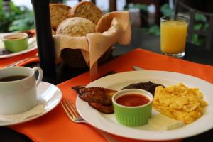 a table with a plate of breakfast food and a cup of coffee at Villa de Antaño in Antigua Guatemala