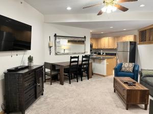 a kitchen and living room with a table and a couch at NEW! Ski-In Ski-Out Breck Condo Amenities Parking 1BR sleeps 4 in Breckenridge