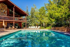 a swimming pool in front of a house at Whispering Red Pine Paradise in Park City