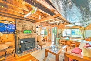a living room with a fireplace and a table at Dreamy Bucksport Hideaway on Freshwater Pond! in Bucksport