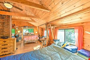 a bedroom with a bed in a room with wooden walls at Dreamy Bucksport Hideaway on Freshwater Pond! in Bucksport
