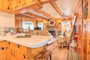 Wrightwood Cabin with Cozy Interior! في رايتوود: مطبخ وغرفة معيشة بجدران خشبية وطاولة