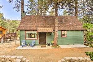 a green house with two blue chairs in front of it at Wrightwood Cabin with Cozy Interior! in Wrightwood