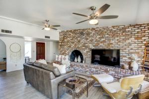 a living room with a large brick fireplace at Stylish Tucson Home with Patio and Private Pool! in Tucson