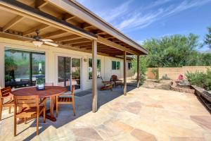 an outdoor patio with a wooden table and chairs at Stylish Tucson Home with Patio and Private Pool! in Tucson