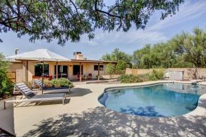 a swimming pool in a yard with a house at Stylish Tucson Home with Patio and Private Pool! in Tucson