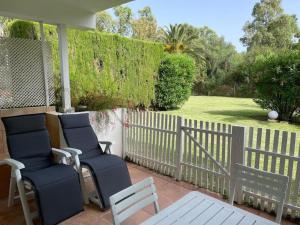 weranda z dwoma krzesłami i płotem w obiekcie Puerto Banus Apartment near beachfront, big sunny terrace, pool, tennis court, parking & movies projector w Marbelli