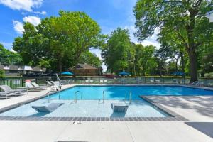 a large swimming pool with lounge chairs and umbrellas at The Howe House in Nashville