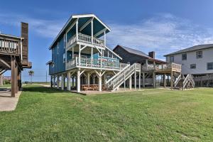 ein großes blaues Haus mit einer Terrasse und einer Treppe in der Unterkunft Oceanfront Surfside Beach Home Deck and Grill! in Surfside Beach