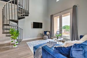 a living room with a blue couch and a staircase at Modern Long Beach Escape about 1 Mi to Shores! in Long Beach