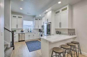a kitchen with white cabinets and bar stools at Modern Mountain Escape Near Slopes, Lakes and Trails in Eden