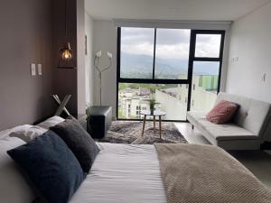 亚美尼亚Hermoso Apartaestudio con excelente ubicación的一间带床、沙发和窗户的卧室