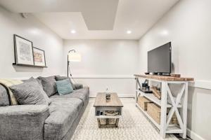 a living room with a couch and a flat screen tv at Dog-Friendly Raleigh Apartment about 5 Mi to Downtown! in Raleigh