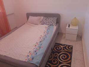 a small bedroom with a bed and a night stand at Lugar calmo na cidade sol 