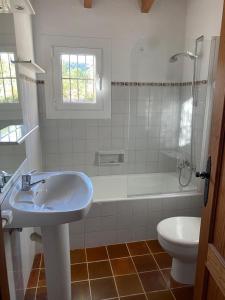 a bathroom with a sink and a tub and a toilet at Can Petrel in Pollença