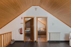 a attic room with a bedroom in a house at Retiro da Serra in Penhas da Saúde