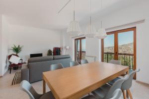 a dining room with a table and chairs and a couch at Retiro da Serra in Penhas da Saúde