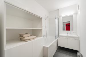 ein weißes Badezimmer mit Badewanne und Waschbecken in der Unterkunft Traunseeresidenzen in Gmunden
