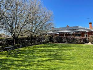 a green yard with a house with a solarium at Twelve on Albert in Beechworth