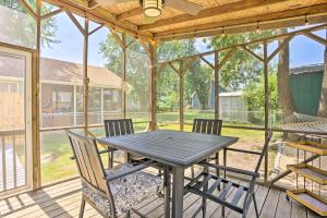 a screened in porch with a table and chairs at Chic Cottage with Private Yard Steps to Beach! in Colonial Beach