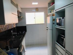 a small kitchen with a refrigerator and a microwave at Casa moderna de praia em Itaipuaçu RJ in Maricá