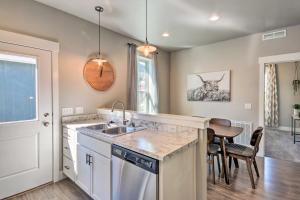 a kitchen with a sink and a table with chairs at Family-Friendly Home, 5 Mi to Downtown Billings! in Billings