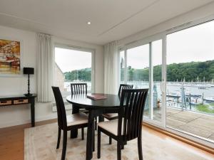 a dining room with a table and chairs and a large window at The Penthouse in Dartmouth