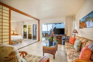 - un salon avec un canapé et une télévision dans l'établissement Alii Villas 128, à Kailua-Kona