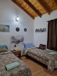 um quarto com duas camas e um sofá em Tu lugar en el fin del mundo em Ushuaia