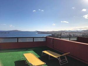 a balcony with two chairs and a view of the water at Apartamento con preciosas vistas al mar in Melenara