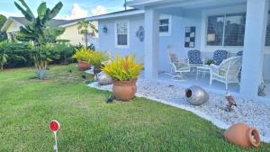 a yard with a house with plants in the grass at Palm Springs 3-Bedroom 2-Bath 5 Miles to the Beach in Lake Worth