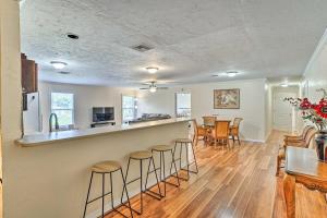 a kitchen and living room with a counter and stools at Sebring Condo with Game Room Less Than 13 Mi to Raceway in Sebring