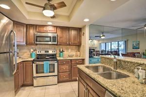 a large kitchen with wooden cabinets and stainless steel appliances at Sea La Vie Sunny Indian Rocks Beach Condo! in Clearwater Beach