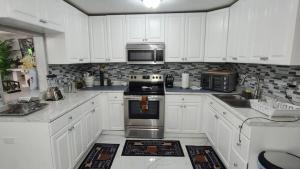 a kitchen with white cabinets and a stove top oven at Palm Springs 3-Bedroom 2-Bath 5 Miles to the Beach in Lake Worth