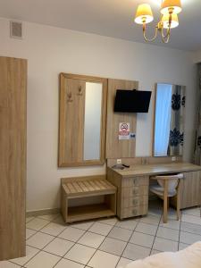 Schlafzimmer mit einem Schreibtisch, einem Waschbecken und einem Spiegel in der Unterkunft Lotos in Rawicz