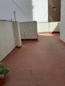um quarto vazio com piso em tijolo e uma parede em La casita de boedo em Buenos Aires