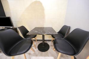 a table with four black chairs and a laptop at Masan First Class Hotel in Changwon