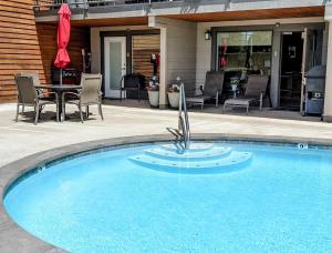 a swimming pool with a table and chairs next to a house at Driftin' Cabanas in Chelan