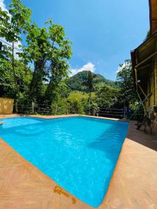 une grande piscine bleue avec une montagne en arrière-plan dans l'établissement hermosa cabaña villa majo, cuenta con el espectacular rio santo domingo, à San Francisco